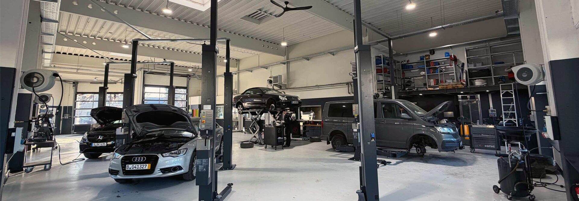 Helle Kfz-Werkstatt mit Hebebühnen und Fahrzeugen als Beispiel einer eigenen Unternehmensimmobilie